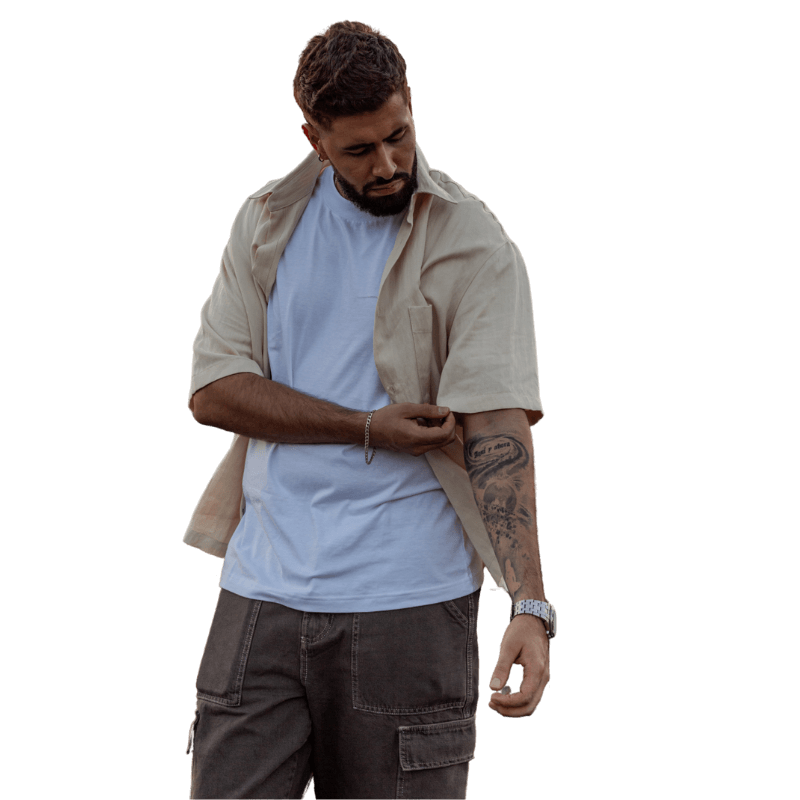 Juanes Sancocho posando de perfil, mostrando tatuaje en el brazo en imagen de fondo transparente.